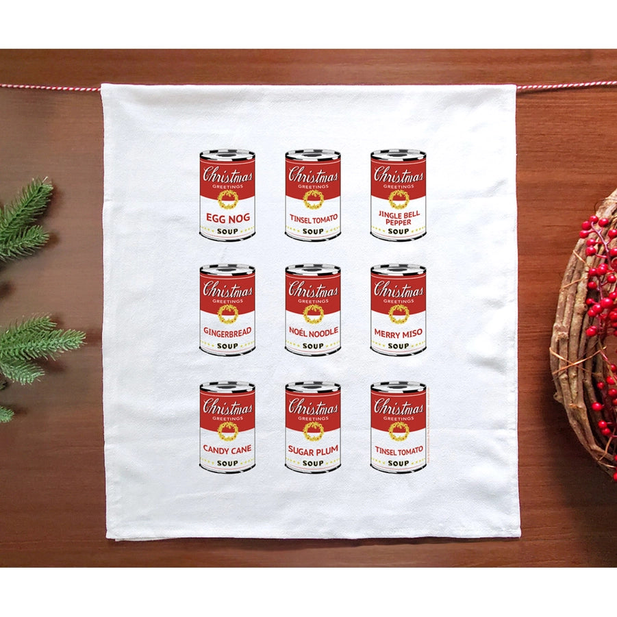 White towel with Christmas soup can designs on a wooden surface