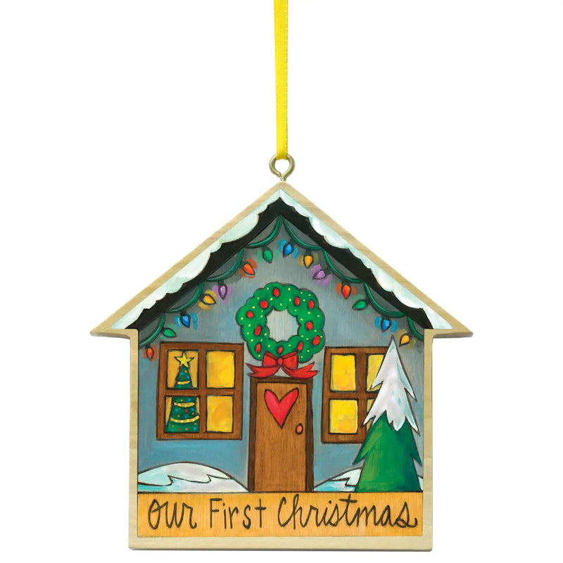 Christmas ornament shaped like a house with a wreath and 'Our First Christmas' text on a white background.
