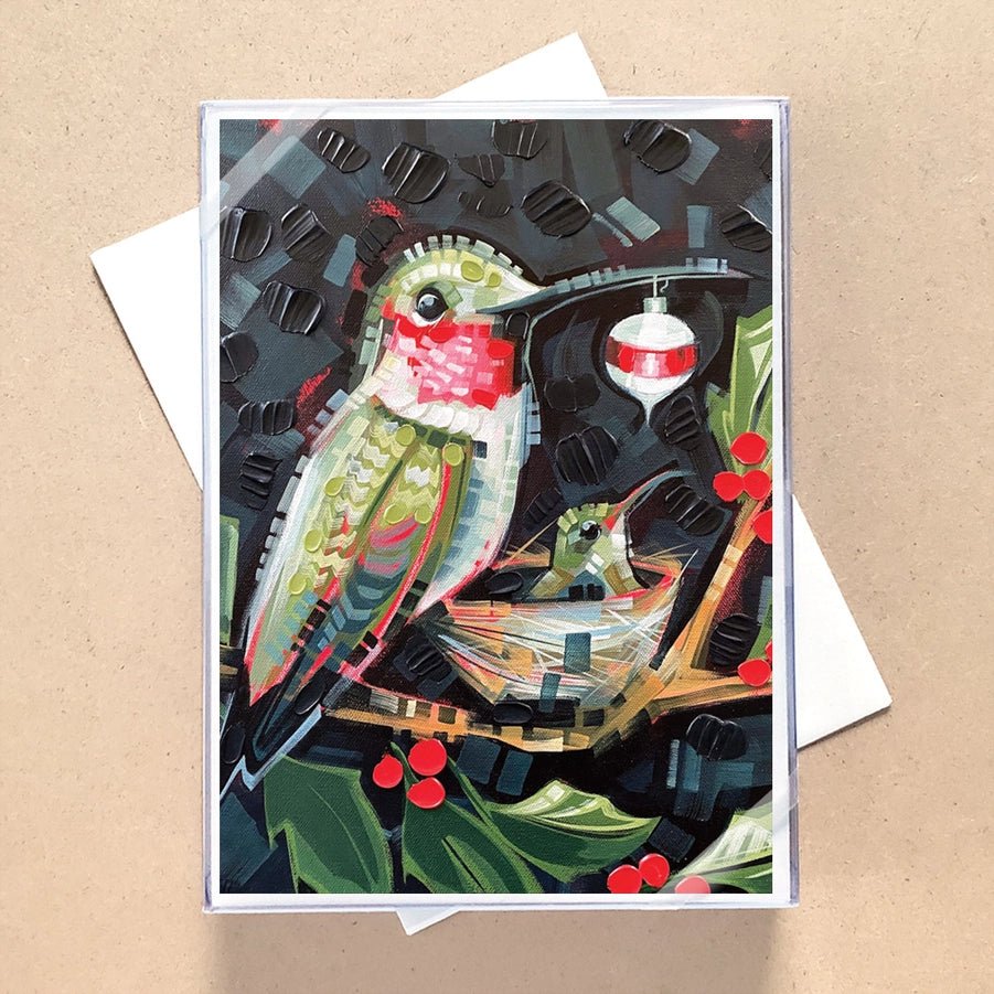 Christmas Card with a hummingbird holding an ornament over a baby bird in nest