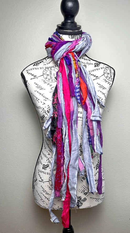 Colorful scarf draped over a mannequin with a script design on a plain background