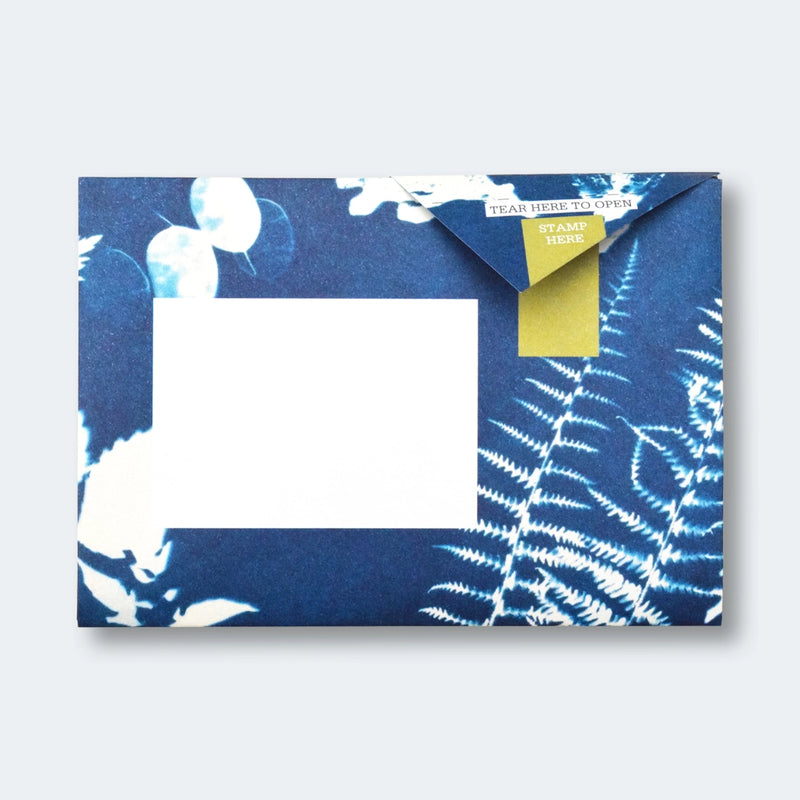 Blue floral-patterned envelope with a white card inside on a light gray background