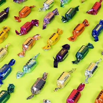 Assorted colorful candy bars on a green background