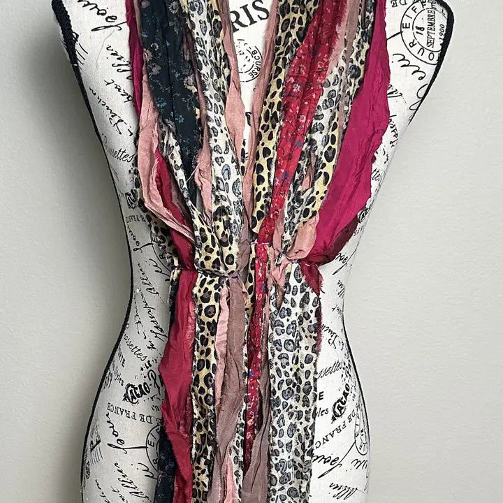 Mannequin wearing a scarf with leopard print and red patterns on a white background