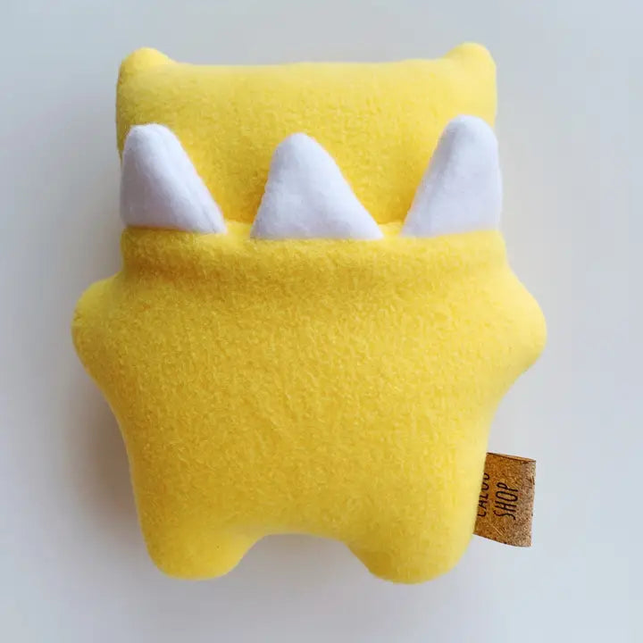 Yellow plush toy with white teeth on a light gray background