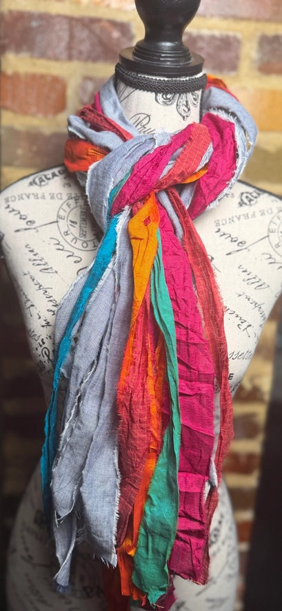 Colorful scarf draped over a mannequin bust with a brick wall background