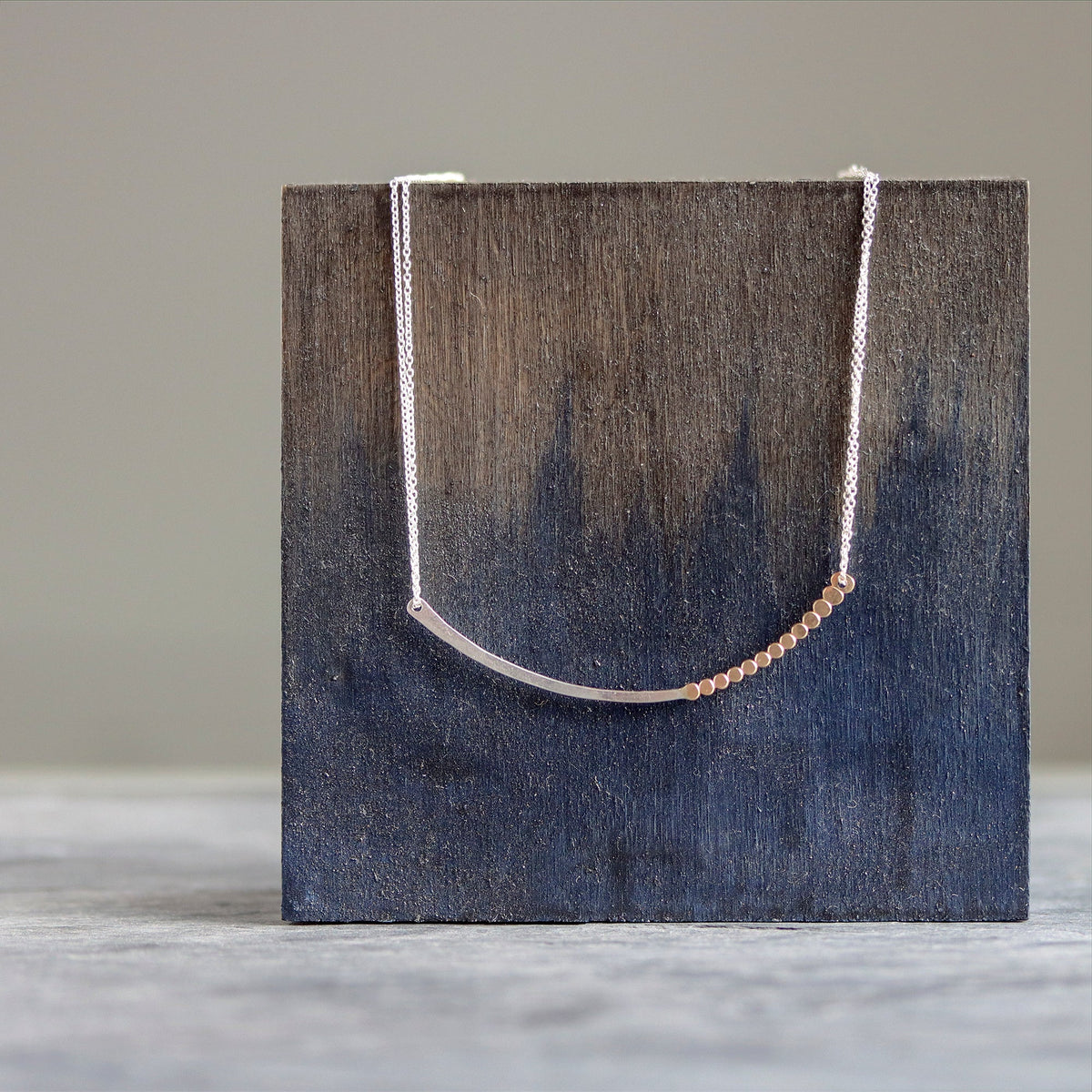 Necklace with a wooden block on a neutral background
