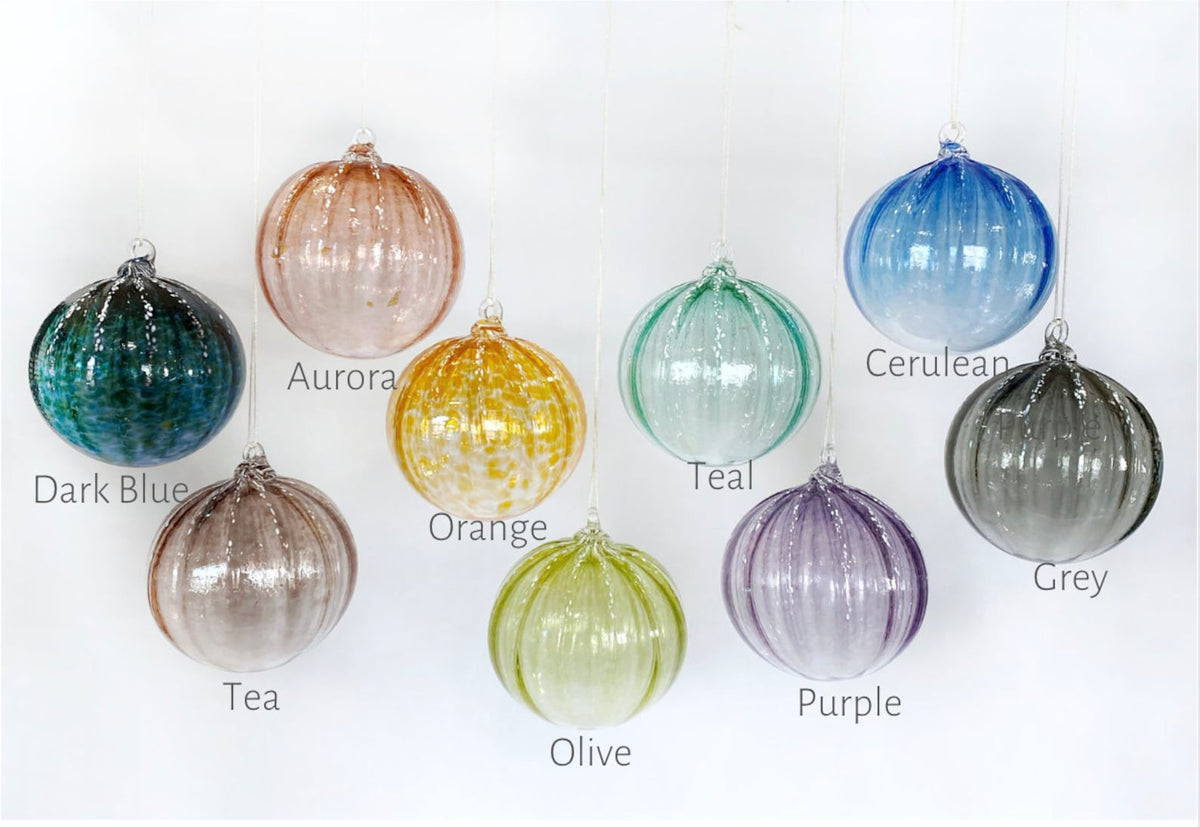 Set of colorful glass ornaments with color labels on a white background
