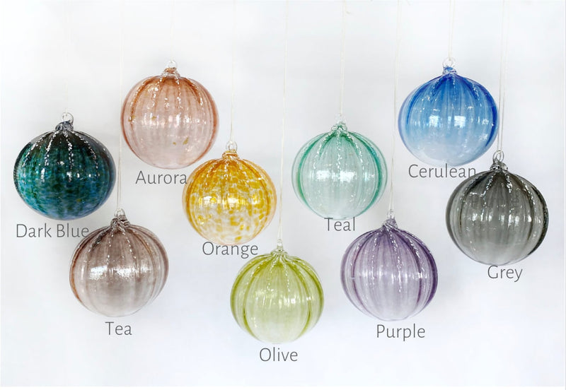 Set of colorful glass ornaments with color labels on a white background