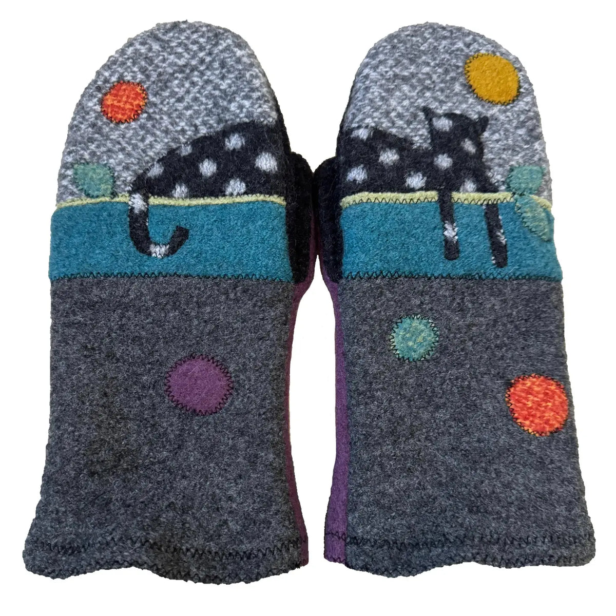 Handmade wool mittens with a spotted black cat and polkdots on white background