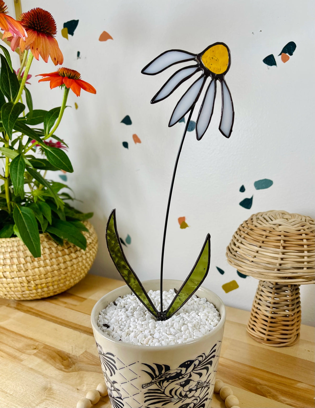 Decorative plant with a stylized flower design on a wooden surface.