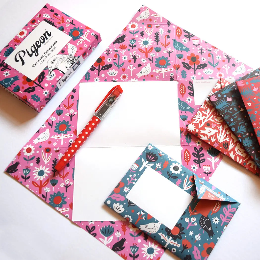 Colorful patterned paper frames and a pen on a white background