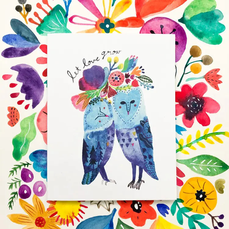 Card with two blue birds and colorful flowers, surrounded by a frame of more flowers and leaves.