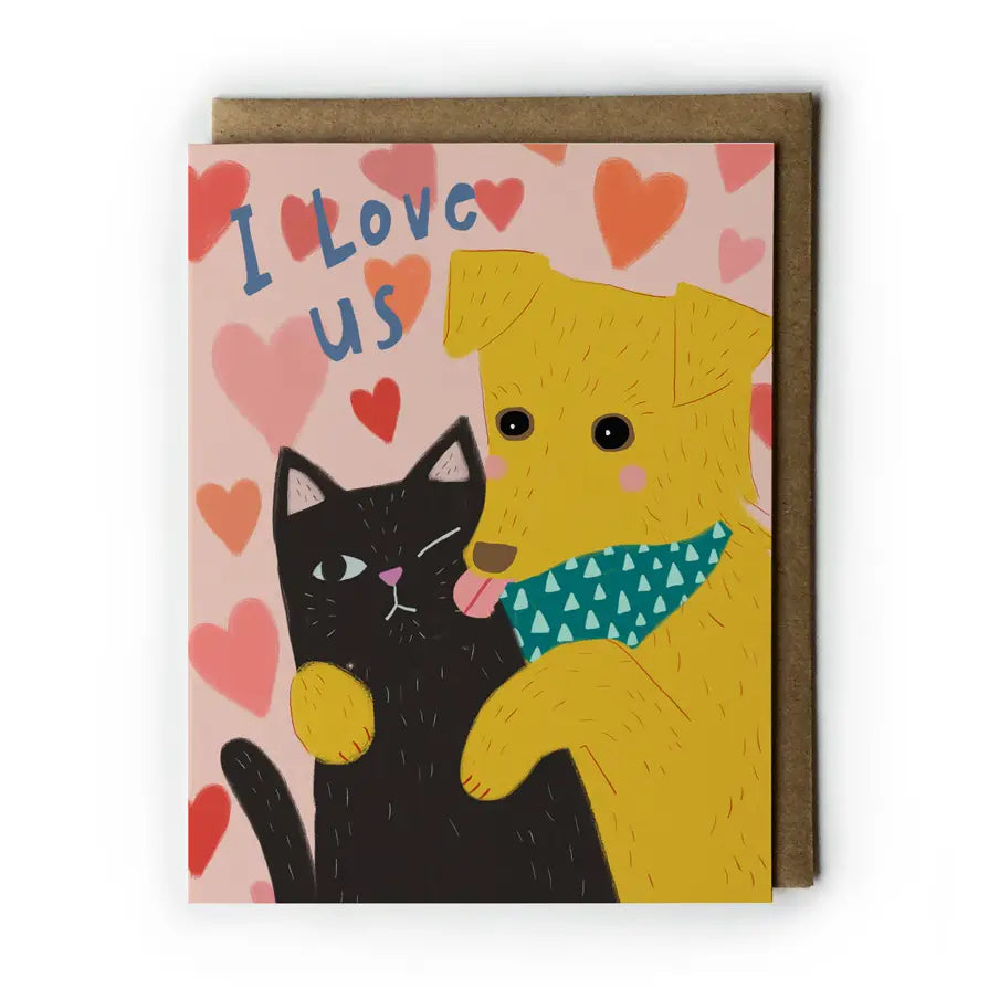 Greeting card with a black cat and yellow dog illustration and 'I Love Us' text on a heart-patterned background.