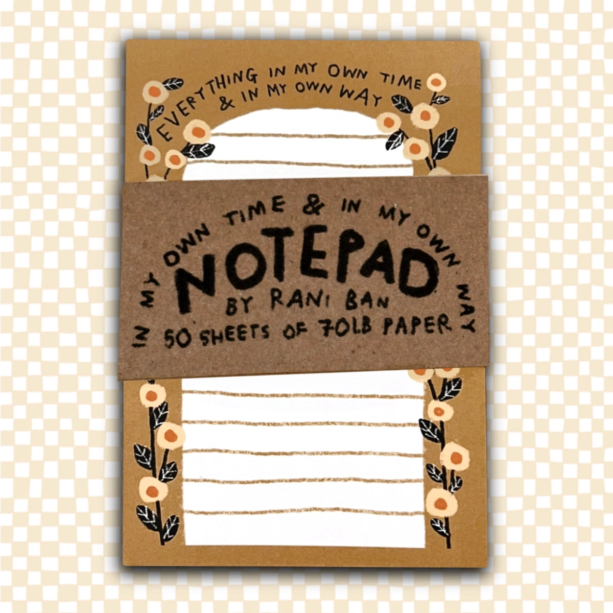 Notepad with decorative cover and text on a checkered background