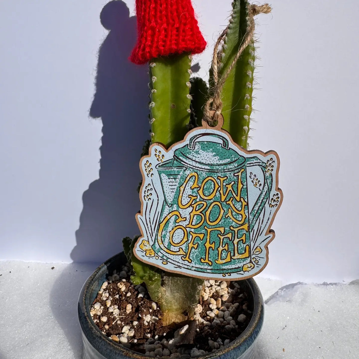 Cactus with a decorative wooden ornament reading 'Cowboy Coffee"
