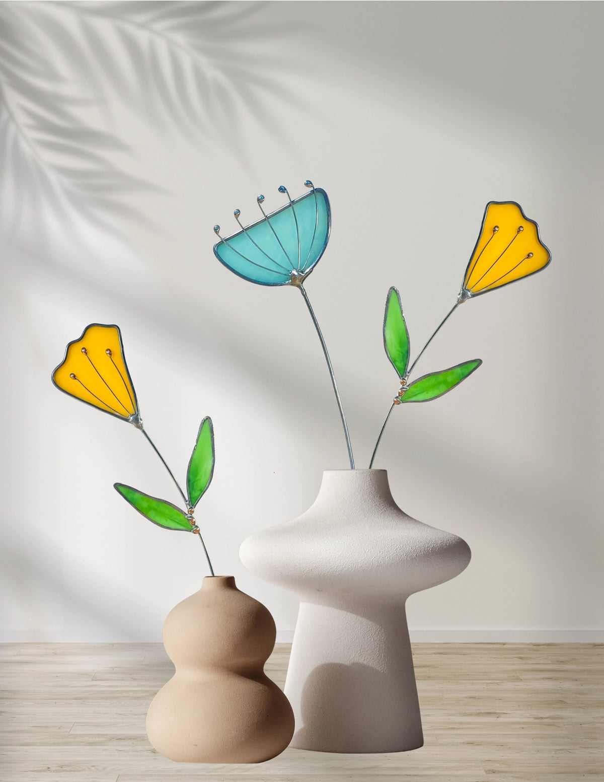 Two vases with colorful floral arrangements on a wooden surface.