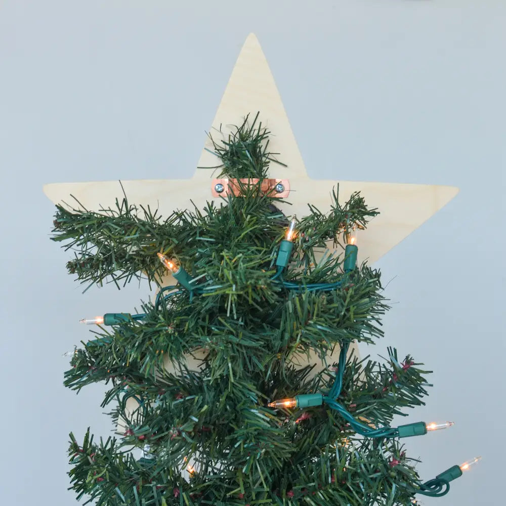 Star-shaped Christmas tree topper with lights on a light blue background