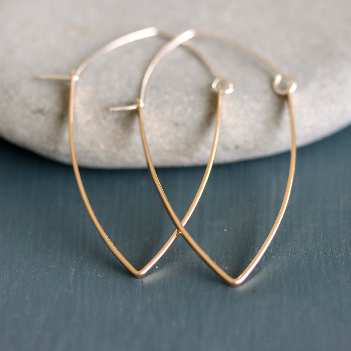 Gold hoop earrings on a textured surface
