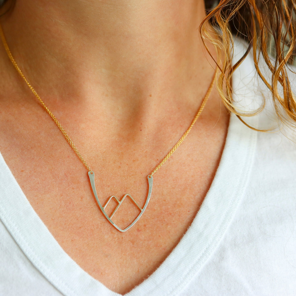 Mixed Metal mountainscape necklace with white t-shirt