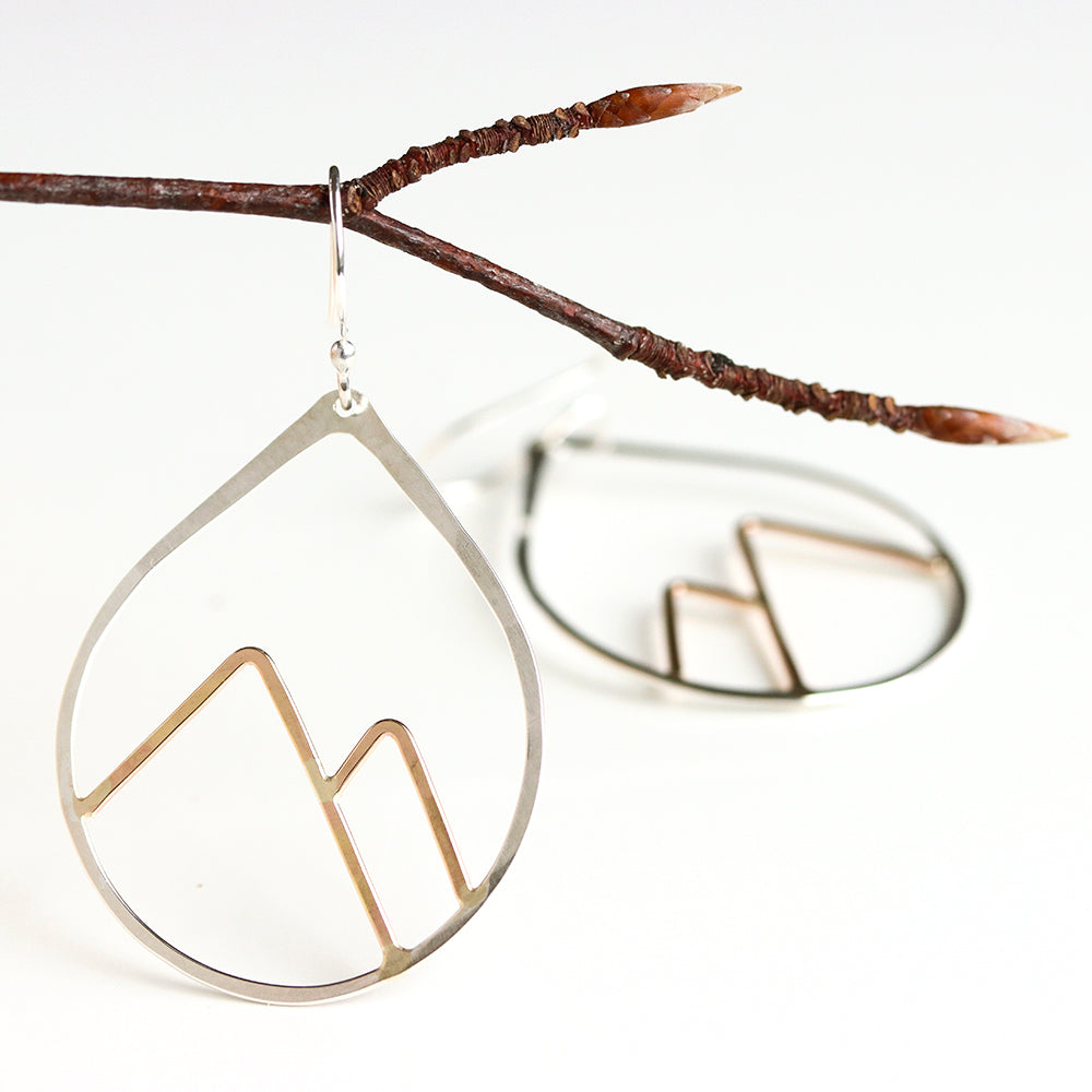 Teardrop-shaped earrings with mountain design on a branch