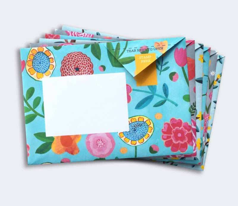 Colorful floral stationery set with envelopes and cards on a light blue background