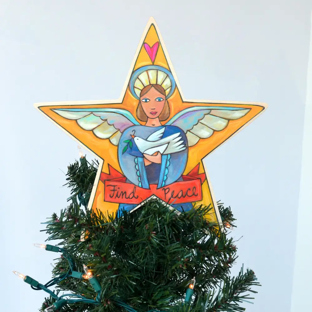 Decorative angel star tree topper on a Christmas tree with a light blue background