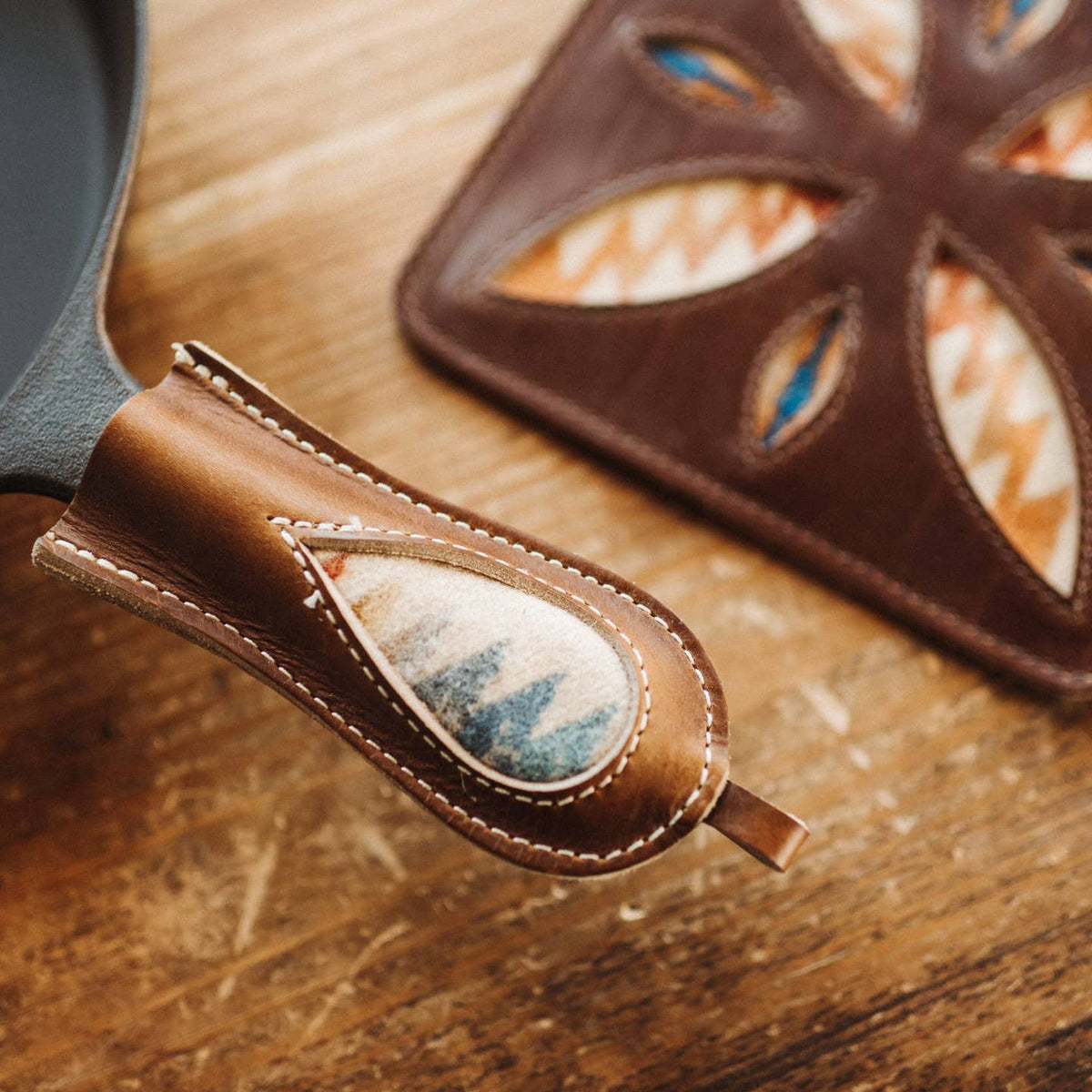 Brown leather sheath with stone inlay on a wooden surface