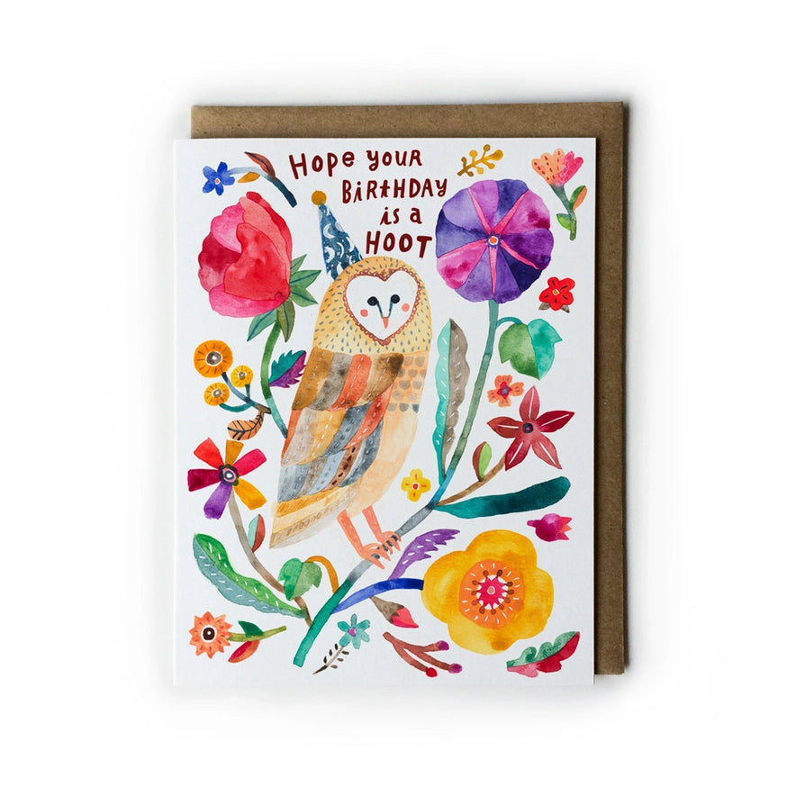 A watercolor-style greeting card with a brown envelope behind it, featuring an owl surrounded by colorful flowers and the text 'Hope your Birthday is a Hoot'.