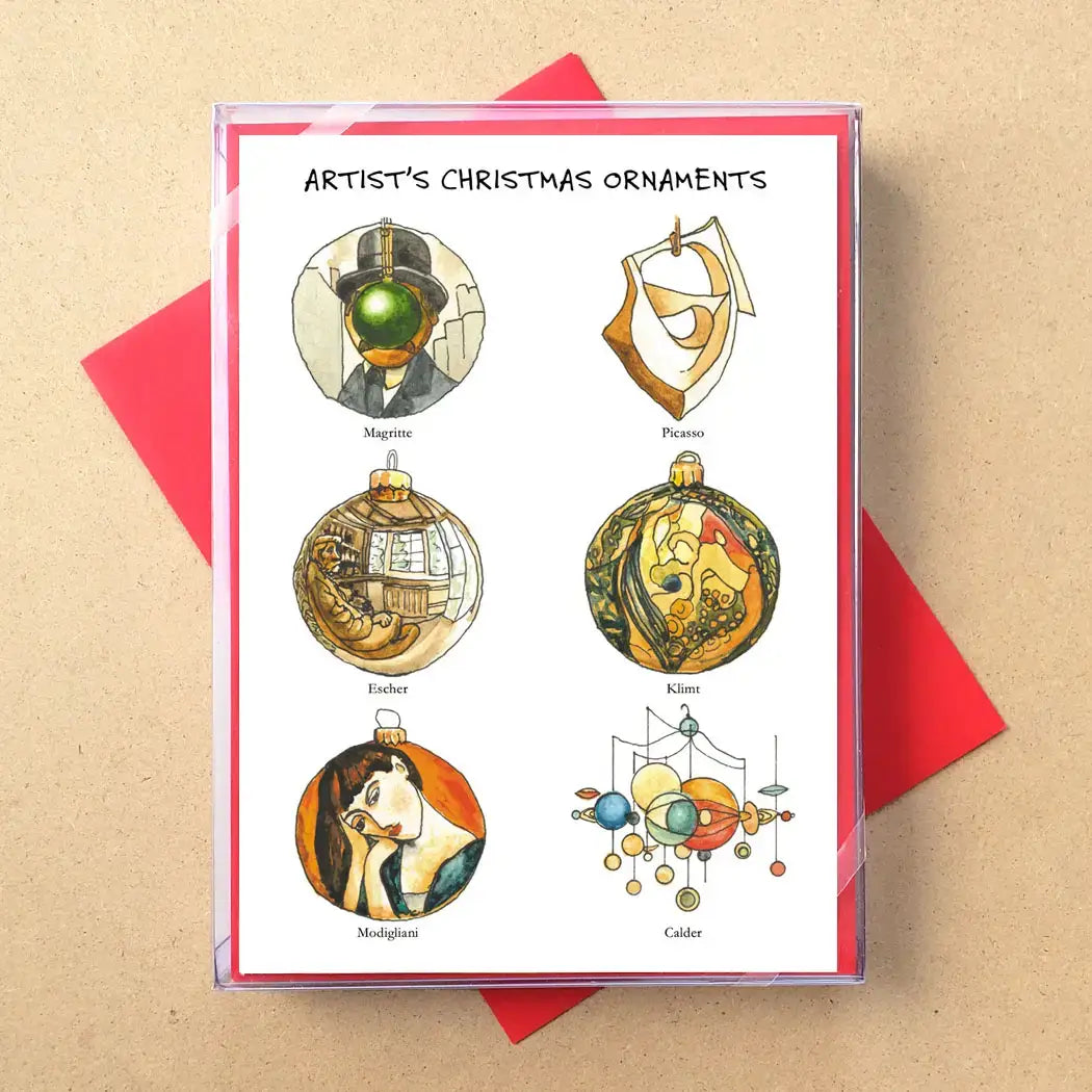 A printed card titled "Artist's Christmas Ornaments" showing six decorative ornament illustrations with artist names beneath them, placed on top of red envelopes against a kraft-paper background.
