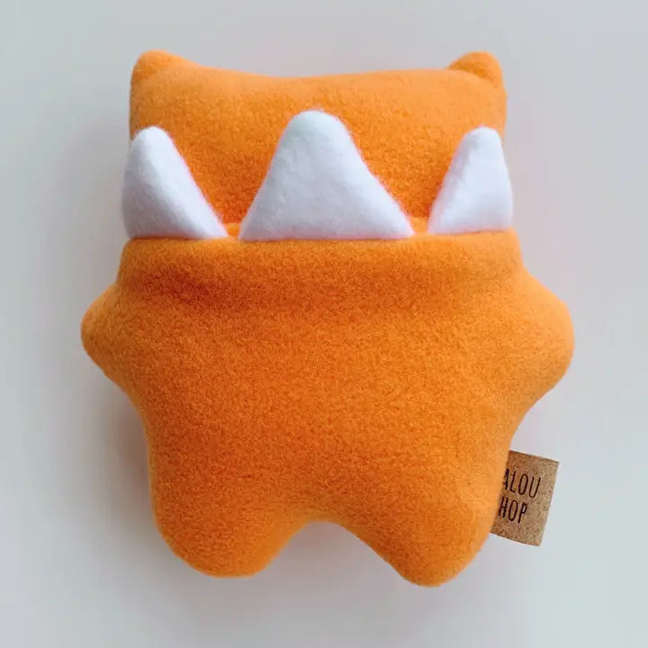 Orange plush toy with white teeth on a light gray background