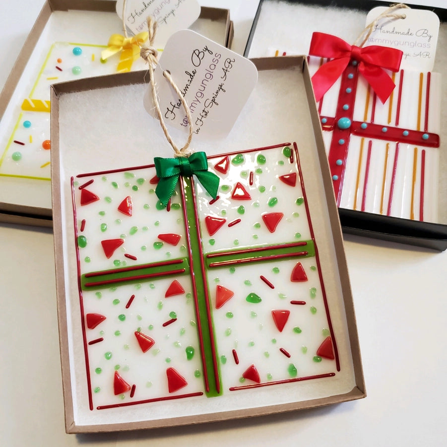 Decorative gift box  fused glass ornaments with red and green accents on a white surface