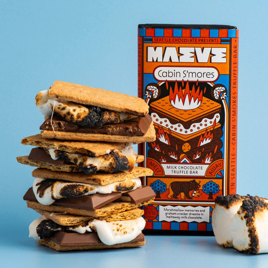 Stack of s'mores with a box labeled 'Maeve Cabin S'mores' on a blue background