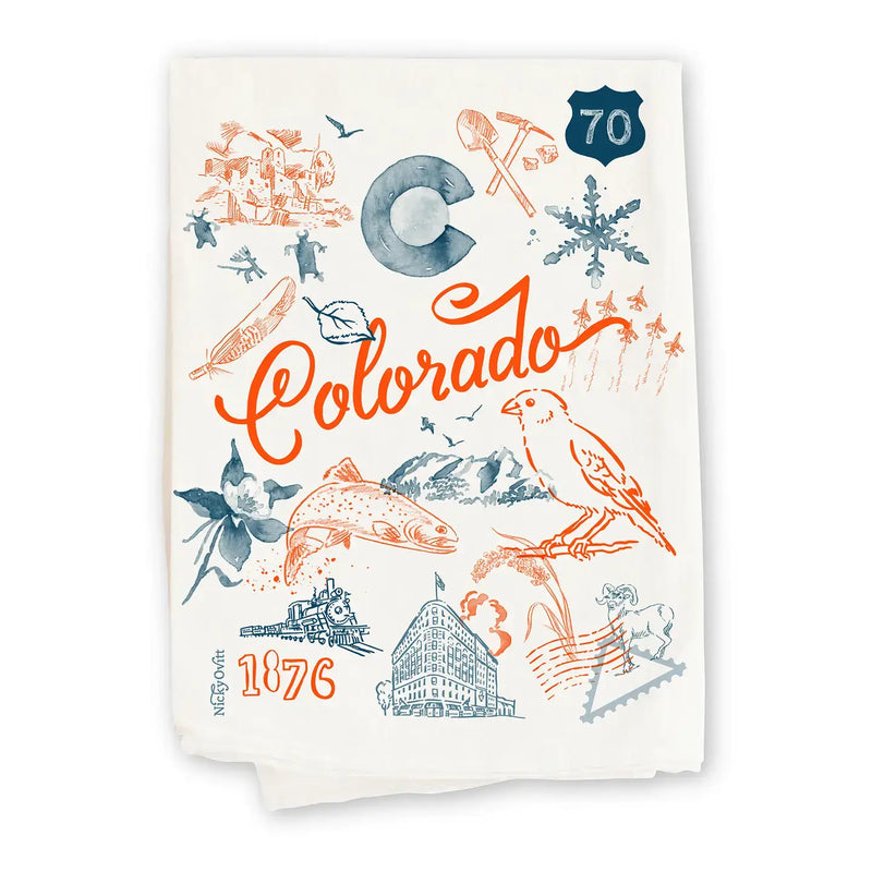 An off-white cotton tea towel featuring a colorful Colorado-themed graphic print with orange and slate blue illustrations, including the word 'Colorado', a mountain, a bird, and '1876'.
