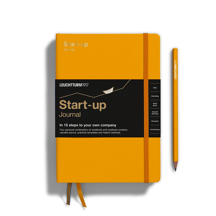 Orange 'Start-up' journal with a pen on a white background