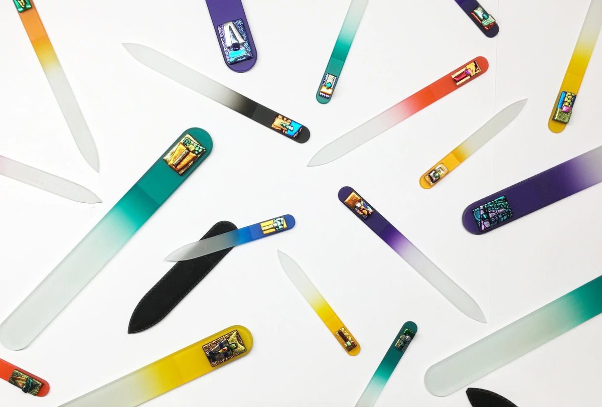Colorful czech glass nail files arranged on a white background