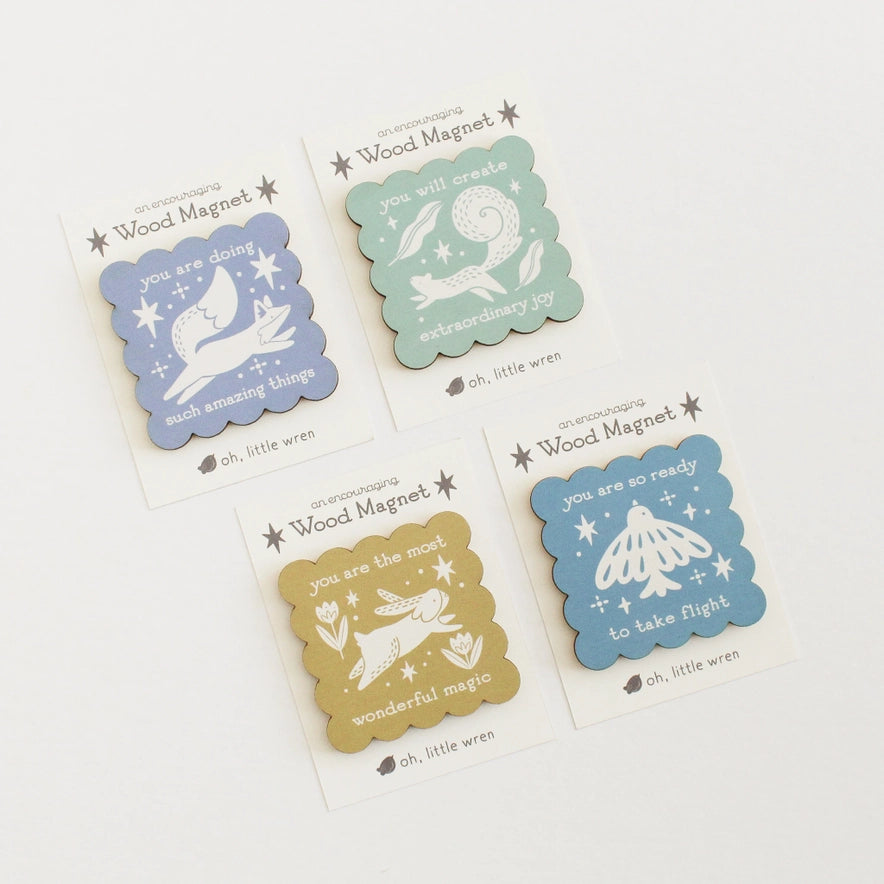 Set of four decorative wood magnets with illustrations and text on a white background