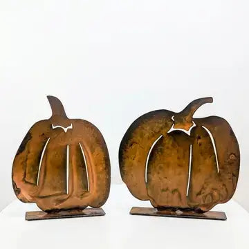 Two rustic metal pumpkin sculptures on small rectangular bases, shown against a plain white background.