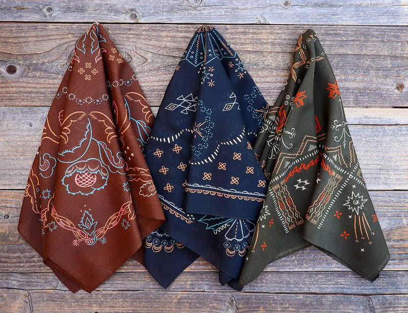 Three patterned scarves in brown, blue, and green on a wooden surface