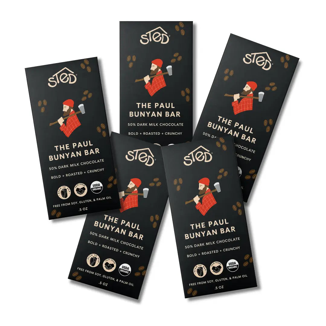 Five chocolate bar packages for The Paul Bunyan Bar are arranged on a plain white background. The packaging is black with white text and a cartoon illustration of a boy chopping wood, with small brown footprint accents.