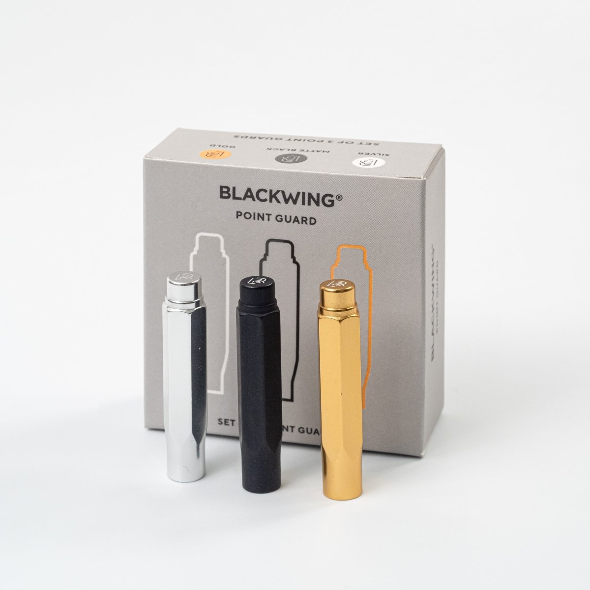 Three pencil tip covers in silver, black, and gold in front of a Blackwing branded box on a white background.
