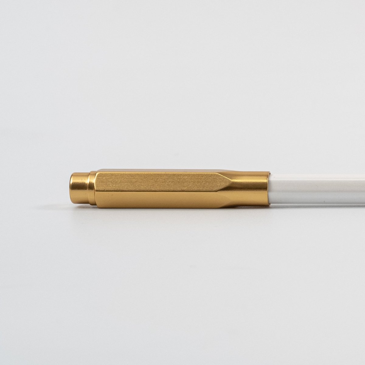 Gold pencil cap on a white background