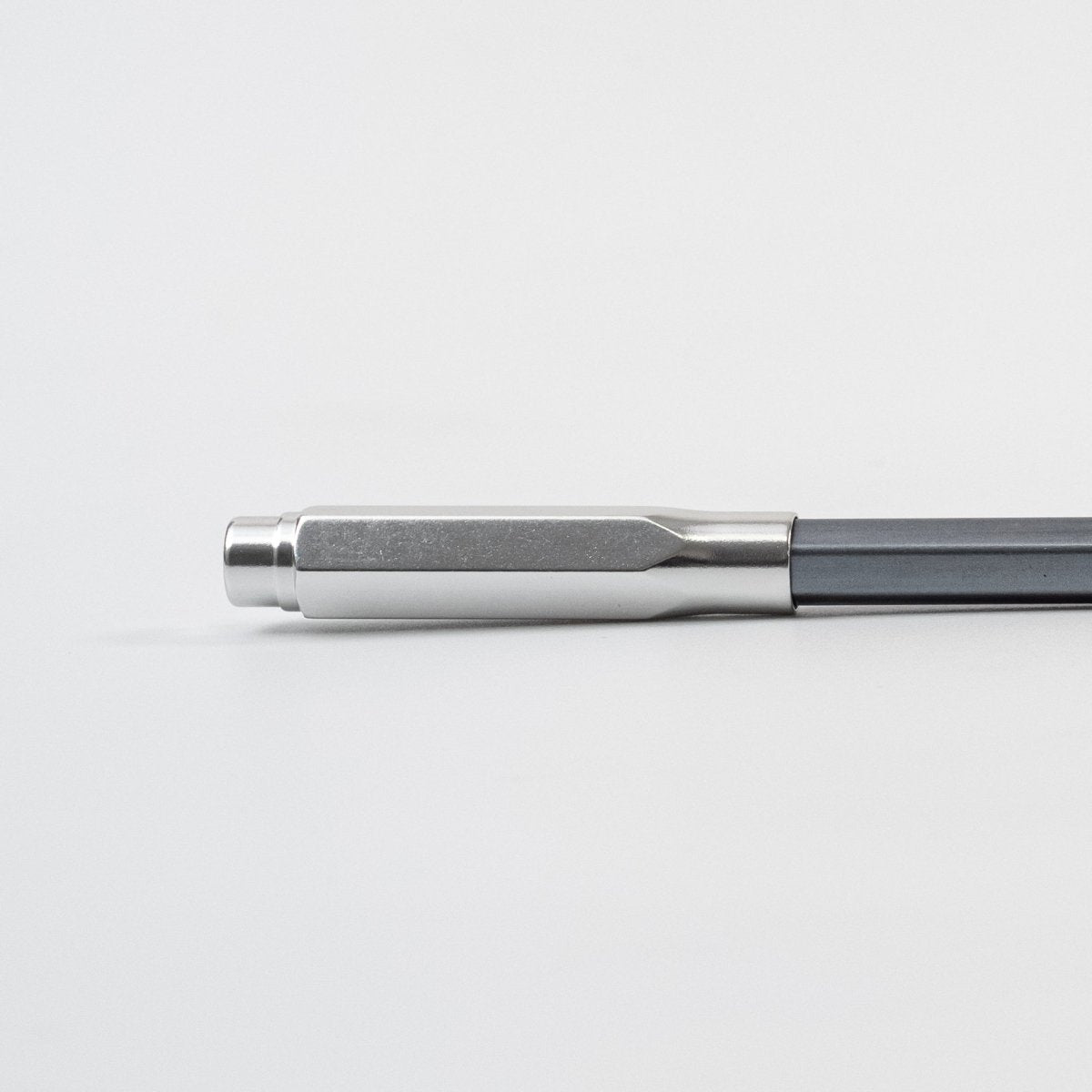 Metallic silver pencil tip cover on a blackwing 602 pencil on a light gray background