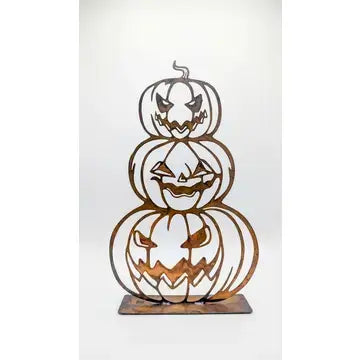 A decorative metal Halloween centerpiece featuring three stacked jack-o'-lantern cutouts on a rectangular base, shown against a plain white background.