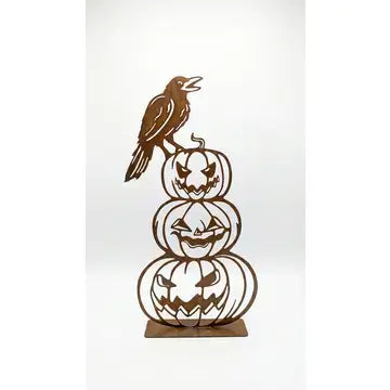 A brown metal Halloween decoration featuring a crow perched on top of three stacked jack-o'-lantern pumpkins, displayed against a plain white background.