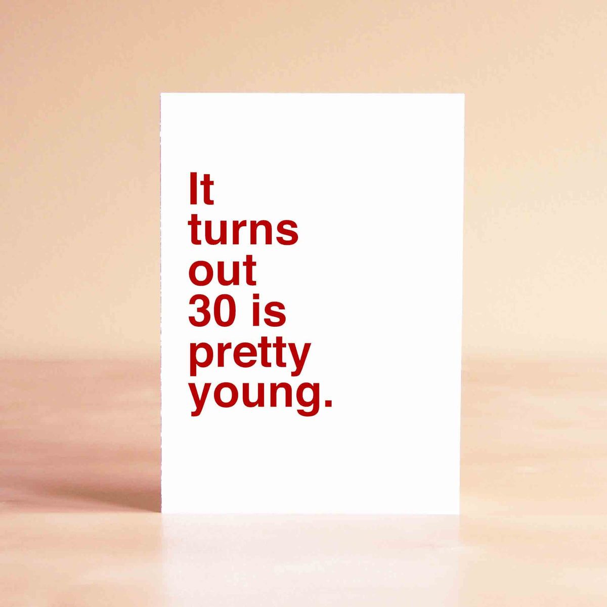 White card with red lettering reading "It turns out 30 is pretty young."