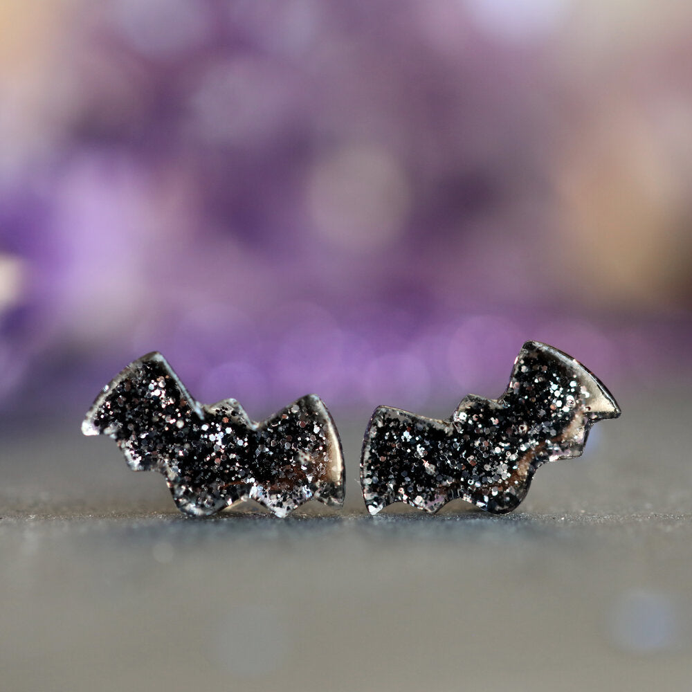 Black Glitter and Resin Bat Earrings with Purple background
