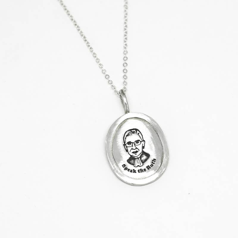 Silver Pendant with a picture of RBG and read "speak the ruth"