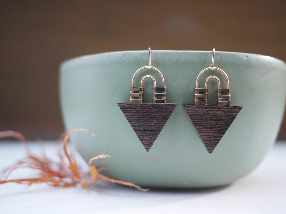 Item Description: Triangle Arch Earrings made from wood laminate yellow gold and hematite beads