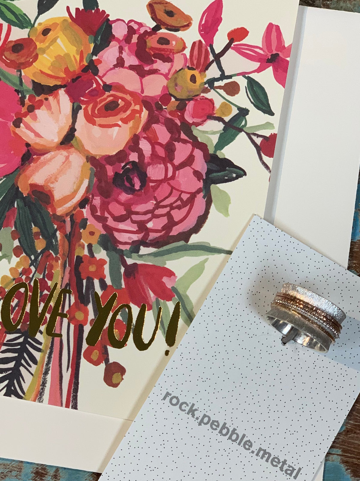 Silver and Copper Ring Displayed with a floral greeting card that read i love you in gold foil