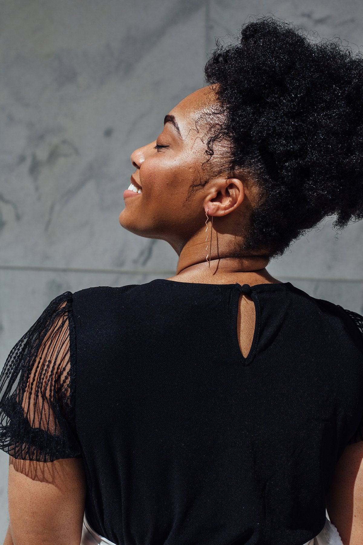 Athena Zigzag-shaped Hoops on smiling African American model in profile